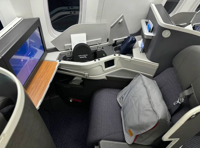 American Airlines' business-class seat featuring bedding in a gray reusable zipper pouch instead of plastic.