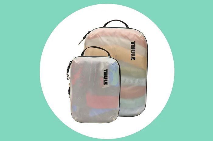 Set of two Thule compression packing cubes, available in two sizes, packed with clothing