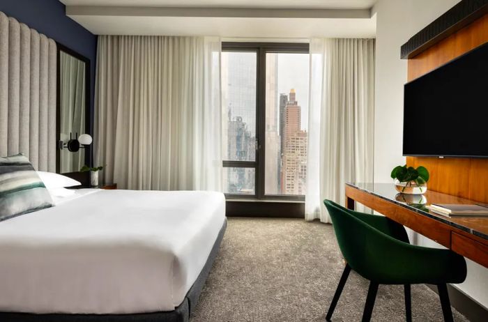 A king-sized bed offering stunning views of New York City from the hotel room