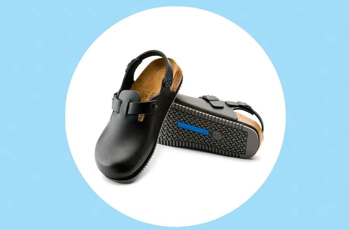 Birkenstock Tokio Super Grip Black shoes displayed on a white circle against a blue background