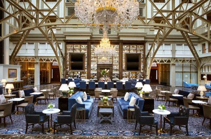 Charming cafe tables and plush couches beneath stunning chandeliers in the Waldorf Astoria Washington D.C.