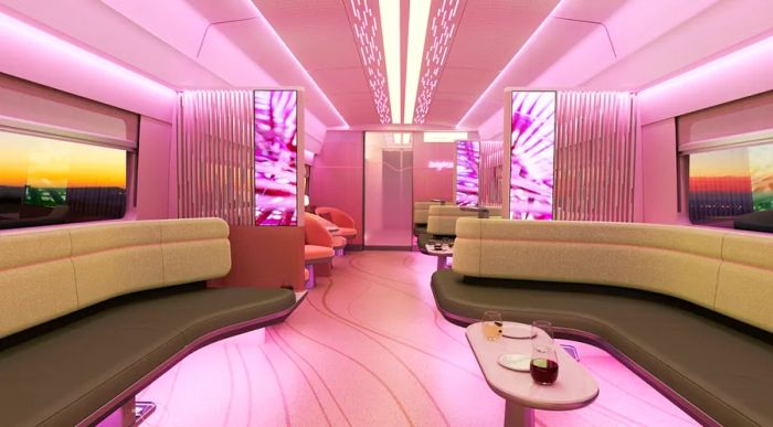 A visual representation of the bar car on the upcoming Brightline West train features spacious padded benches lining the walls, trendy pink lighting, and an oval coffee table.