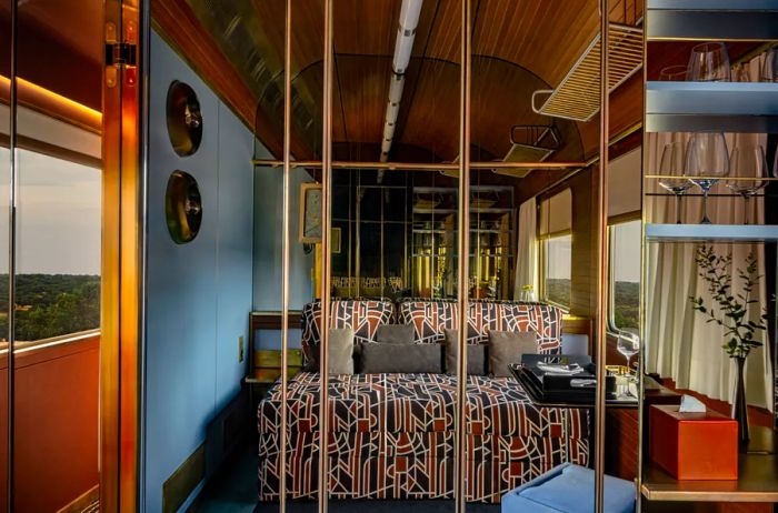 A mirrored wall showcases a luxurious cabin bed aboard the La Dolce Vita Orient Express train.