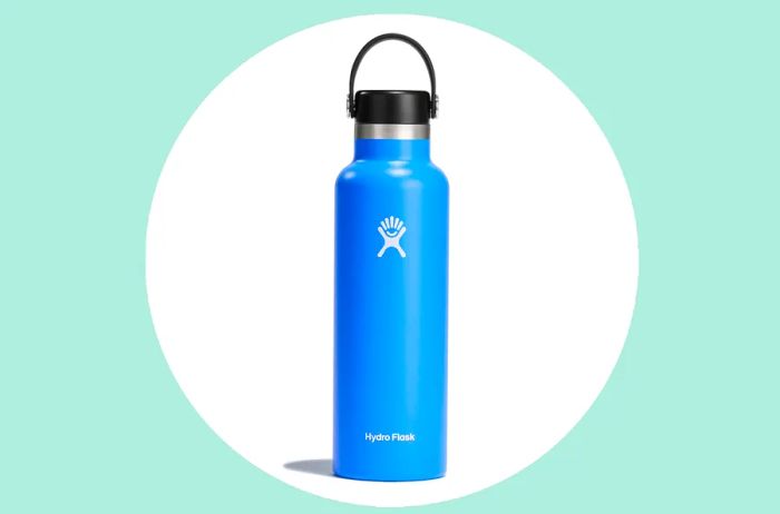 The Hydro Flask standard-mouth water bottle in Cascade blue against a light green backdrop