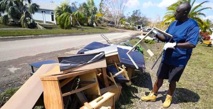 Andre McCourt discards water-damaged furniture from his home in North Port, Florida.