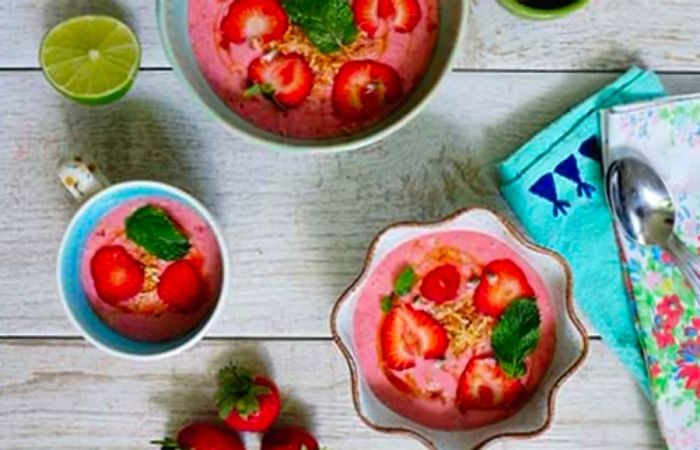 Three bowls filled with strawberry coconut soup.