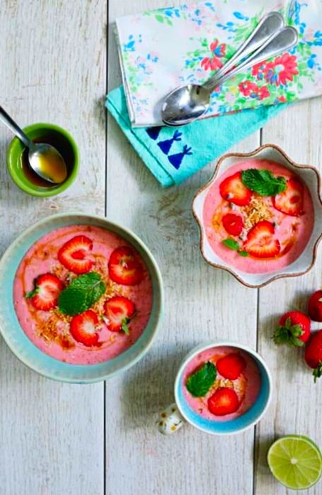 Three bowls of varying sizes filled with strawberry coconut soup.