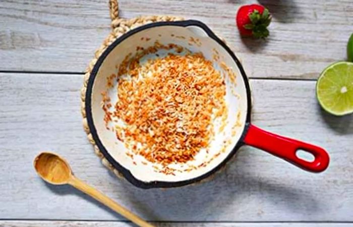 Toasted coconut being prepared in a skillet.