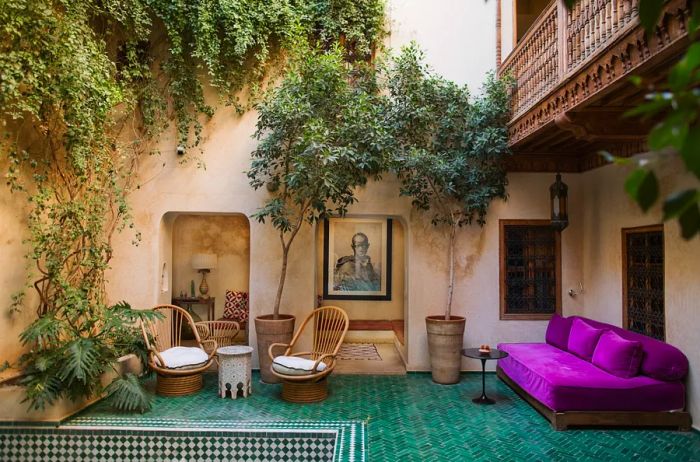 A cozy lounge at El Fenn in Marrakech, featuring a purple sofa and vibrant blue-tiled floors.