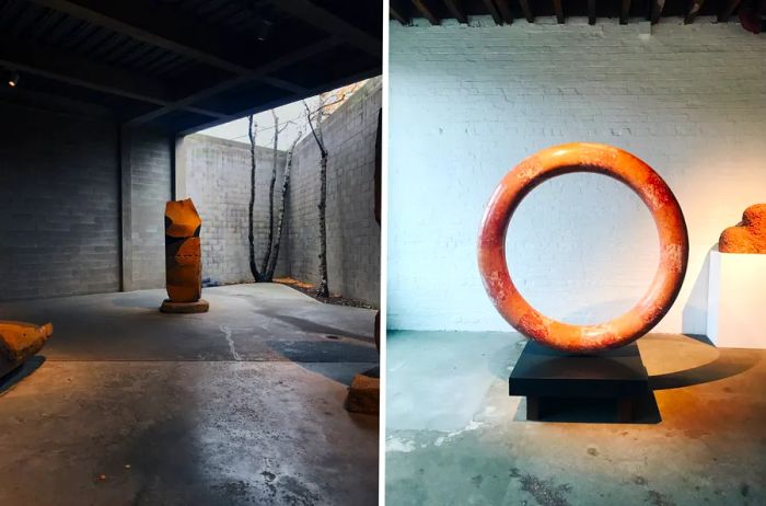 Two sculptures on display at the Noguchi Museum in Brooklyn: an outdoor vertical piece (left) and a stone circle (right).