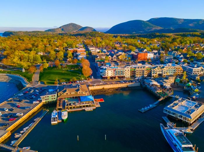 Aerial view of Bar Harbor's historic town center at sunset, with Cadillac Mountain in Acadia National Park visible in the background, Bar Harbor, Maine ME, USA.