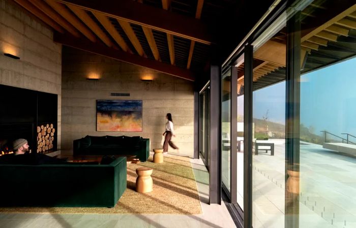 Interior of a public space with green sofas and floor-to-ceiling windows at Flock Hill Lodge.