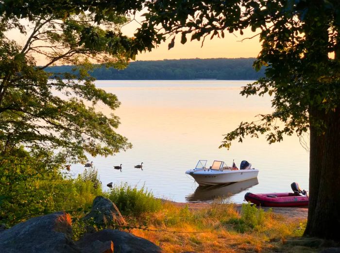 Two small boats docked near the shore at Burlingame State Park, seen through the trees