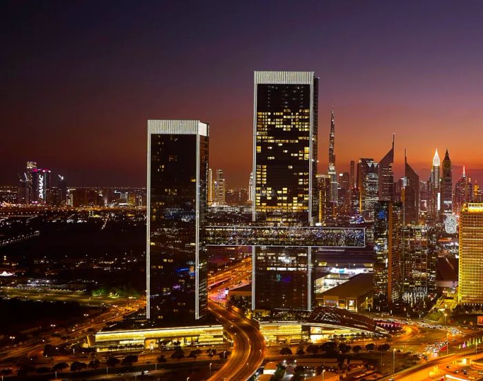 An H-shaped tower with a cantilevered section illuminated at night