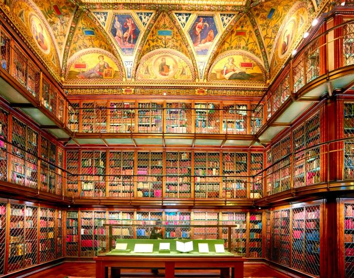 An elegant, vintage-style library with three levels of books and beautifully painted walls at the Morgan Museum.