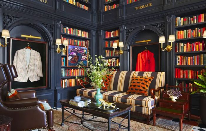 A cozy armchair and couch positioned beside bookshelves at the Graduate Princeton