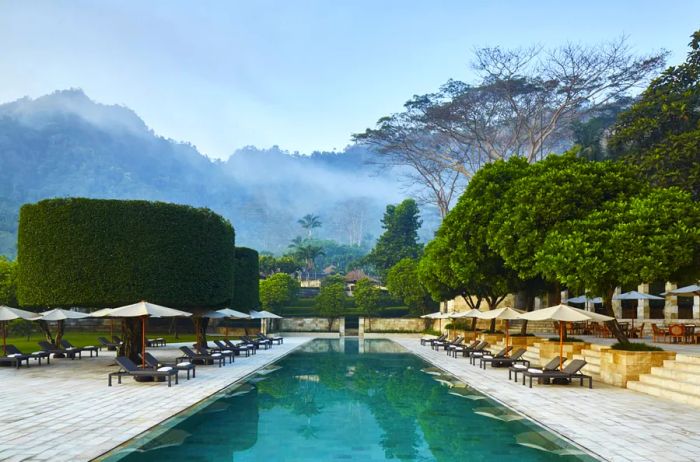 The main swimming pool at Amanjiwo overlooks lush green mountains.