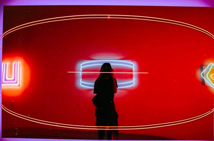 A visitor stands in a mirrored installation at the Museum of Neon Art in Glendale, California.