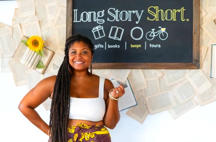 Kristin White poses in front of a blackboard sign for Long Story Short.