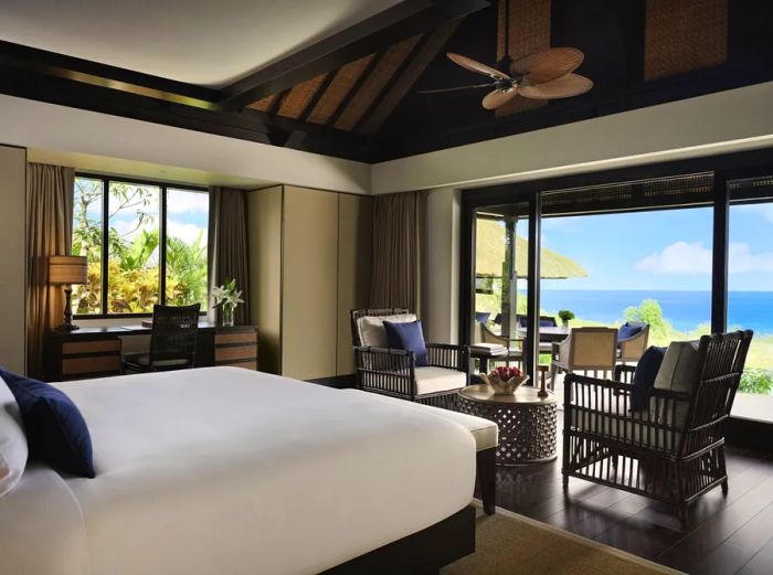 The guest accommodations at Raffles Bali are adorned with rattan furniture and feature verandas that offer stunning ocean views.