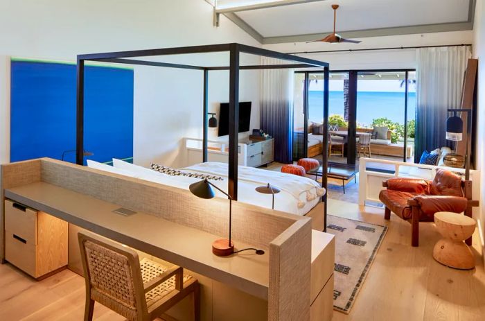 Spacious, contemporary guest room featuring a desk and floor-to-ceiling windows overlooking the ocean.