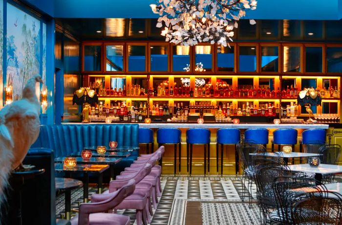 An opulent bar featuring a white taxidermy peacock, luxurious leather banquettes, cobalt blue stools, a decorative tiled floor, and a chandelier resembling white foliage.