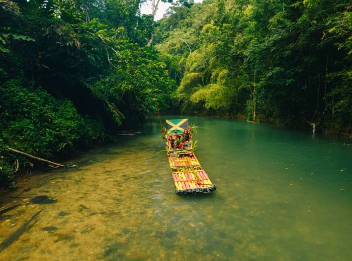 A flatboat gliding on the Benta River, surrounded by lush greenery.