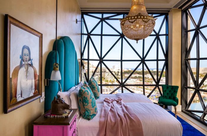 A guestroom at the Silo Hotel featuring a chandelier, modern African art, and expansive floor-to-ceiling windows.