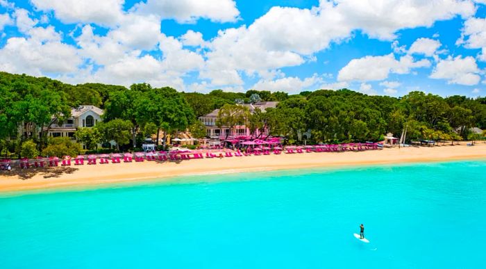 Sandy Lane beach resort in Barbados, a beachfront resort featuring a person on a stand-up paddleboard in the ocean.