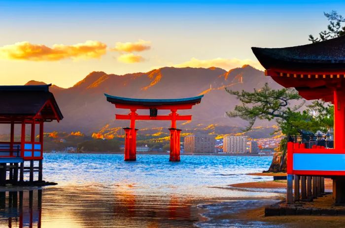 A view of the striking red-orange gate standing in the waters surrounding Miyajima Island.