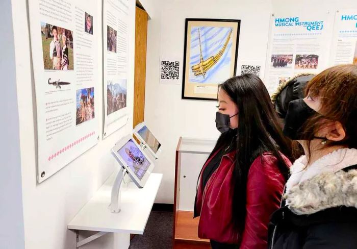 Visitors observing a display inside the Hmong Cultural Center in St. Paul