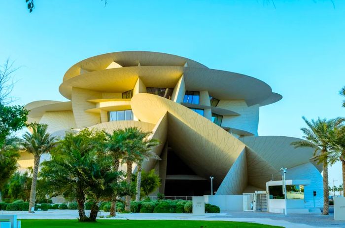 The exterior of the National Museum of Qatar features captivating architectural designs resembling various planes that evoke the look of a desert rose crystal.