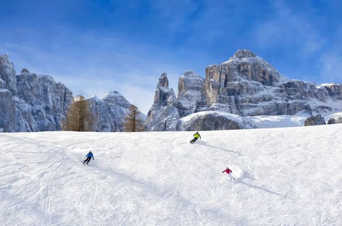 Three skiers enjoying the Dolomites against a backdrop of dramatic mountain peaks