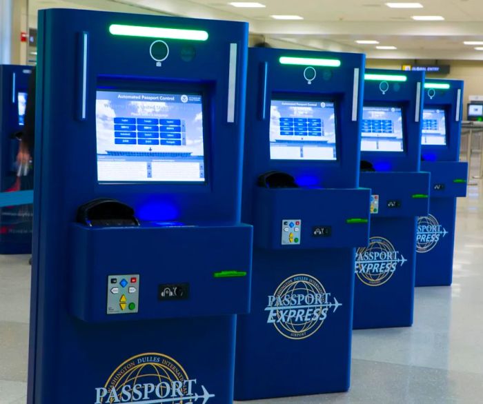 A row of four blue Passport Express machines at the airport