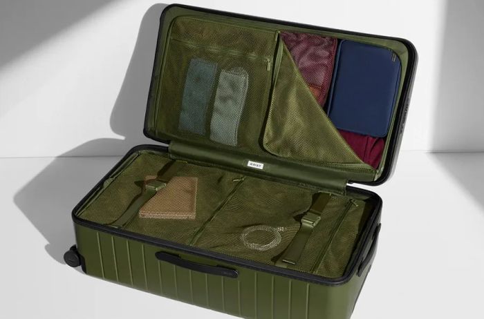 An opened Away Trunk suitcase in olive green