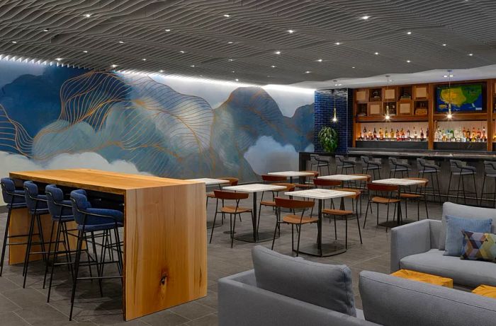 The newly upgraded bar in the Centurion Lounge at San Francisco International Airport features light wood furnishings and gray sofas.