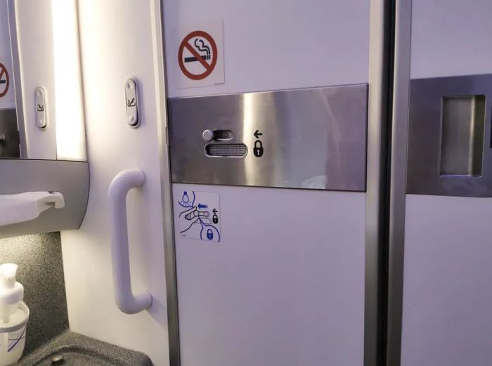 The inside of an airplane restroom, including parts of the sink and door