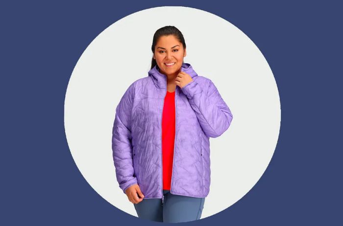 Woman showcasing the Outdoor Research SuperStrand LT Hoodie in lavender