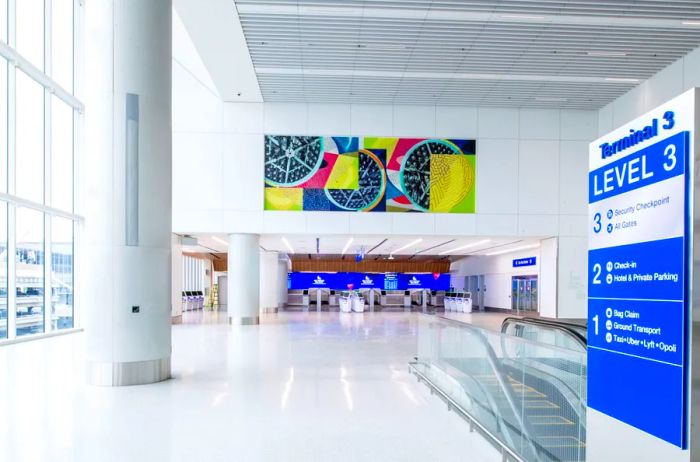 Delta's vacant white Terminal 3 at LAX showcasing a large, vibrant piece of overhead artwork