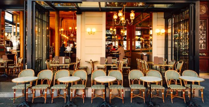 A typical view of a Parisian street featuring café tables in Paris, France. The city's architecture and landmarks create a stunning cityscape.