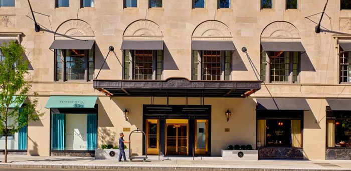 The exterior of The Newbury Boston showcases a prominent black awning and elegant stone walls.