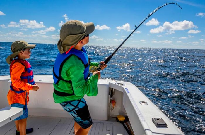 Two children enjoying a fishing trip in a boat in the Gulf of Corpus Christi, Texas