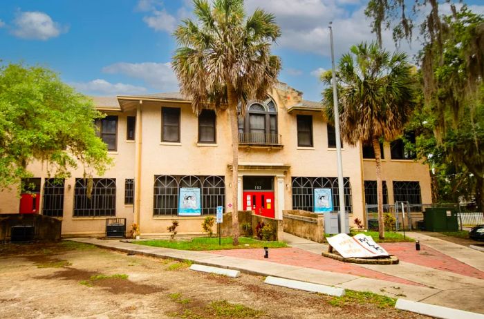 The facade of the Lincolnville Museum, surrounded by towering palm trees