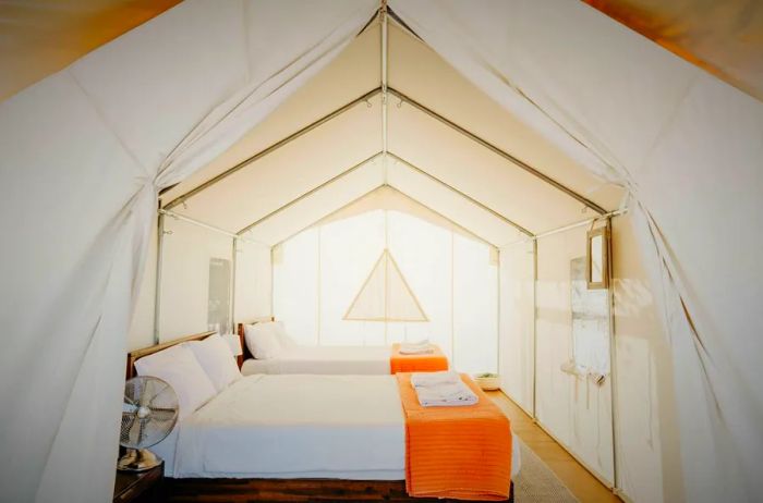 A white canvas tent featuring two beds at Wildhaven Yosemite.