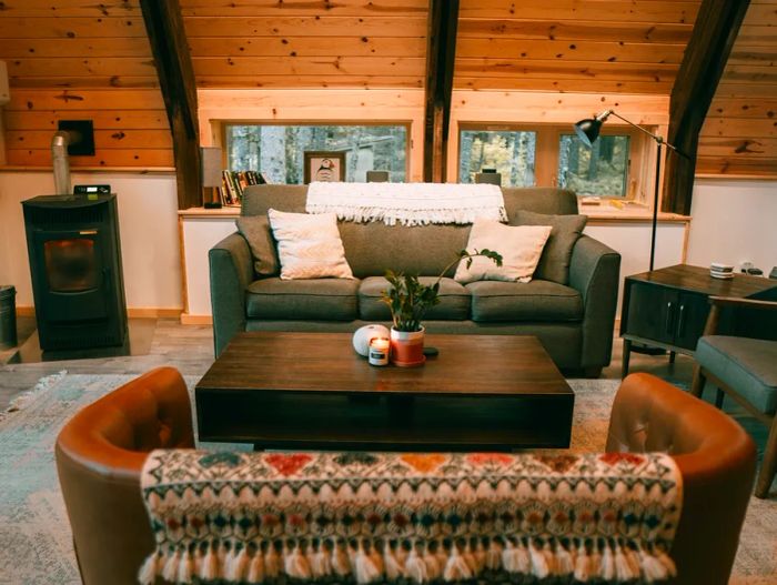 A-frame lodgings at Salted Roots featuring a cozy tufted sofa and wooden interiors