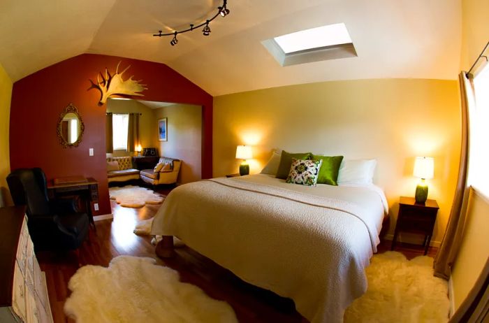 A guest room at Ultima Thule Lodge features wooden floors topped with plush white carpets, accented by an antler on the wall.