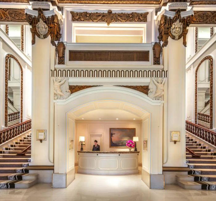 The concierge desk at The Peninsula Hong Kong is bordered by two elegant staircases.