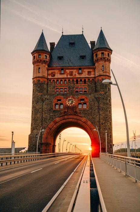 A stunning photograph capturing the sunset through the archway of the Nibelung Tower in Worms, Germany