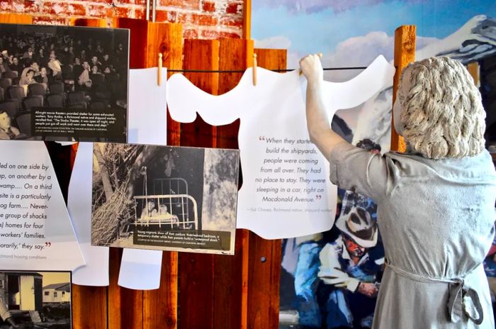 An exhibit featuring a mannequin hanging a paper shirt on a clothesline, surrounded by images and educational materials