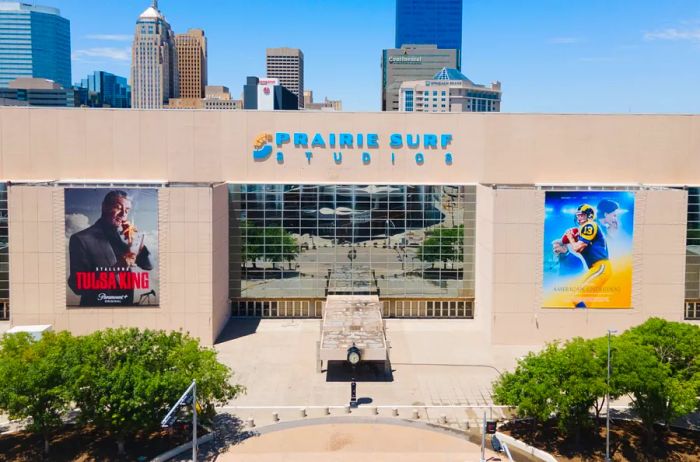 The beige exterior of Prairie Surf Studios adorned with movie posters for Tulsa King and American Underdog.